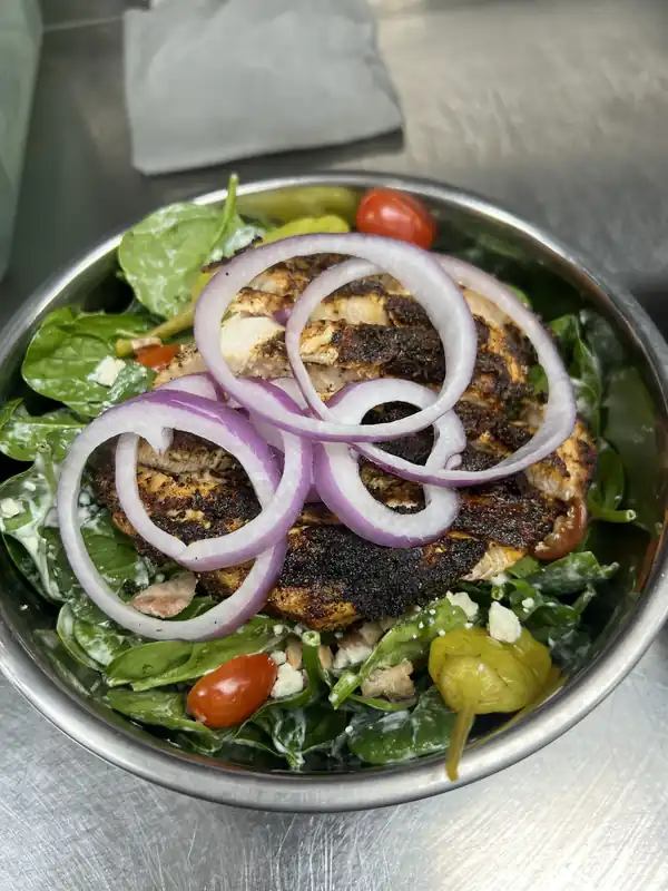 A blackened chicken salad with red onion