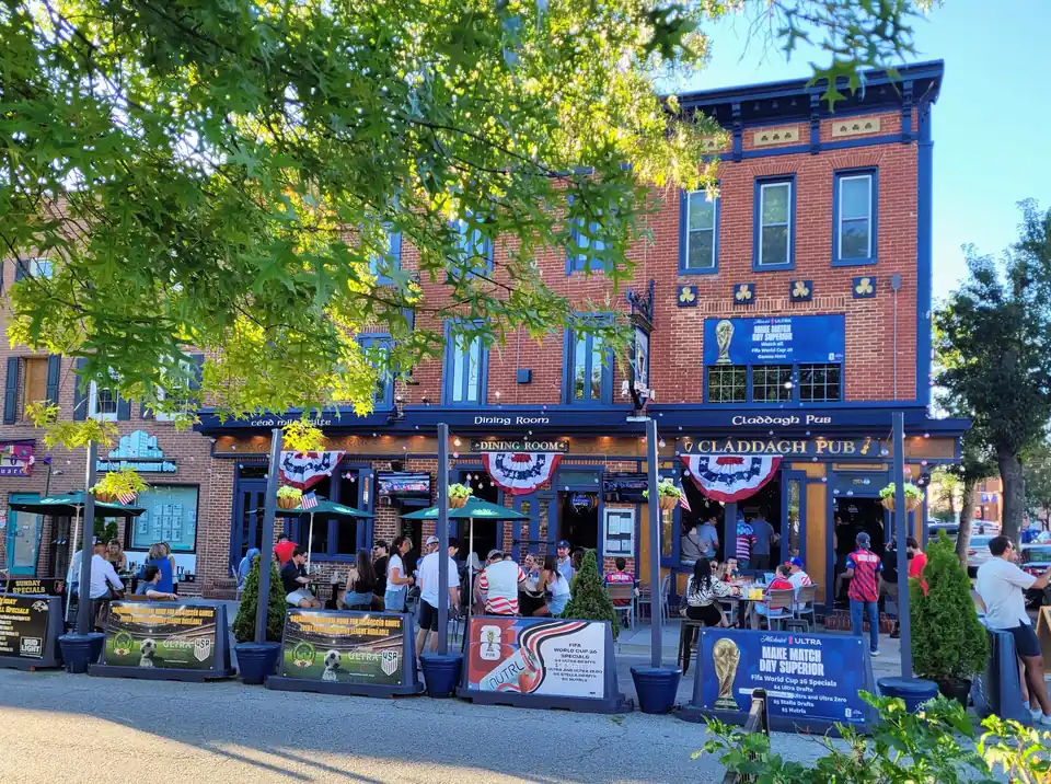 The Claddagh Pub corner on Canton Square in daylight, with the sidewalk patio out front