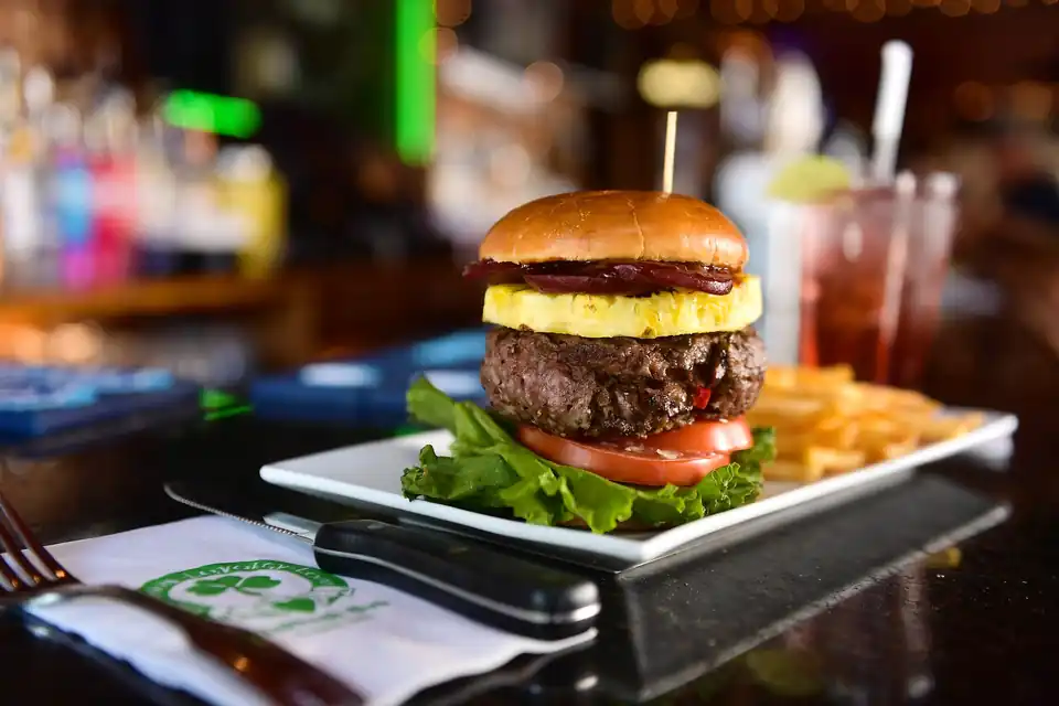 A burger topped with a fried egg on the bar top