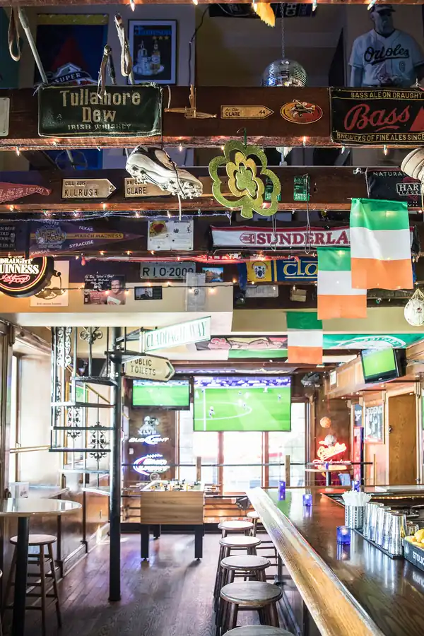 A ceiling covered in old pub signs and an Irish flag