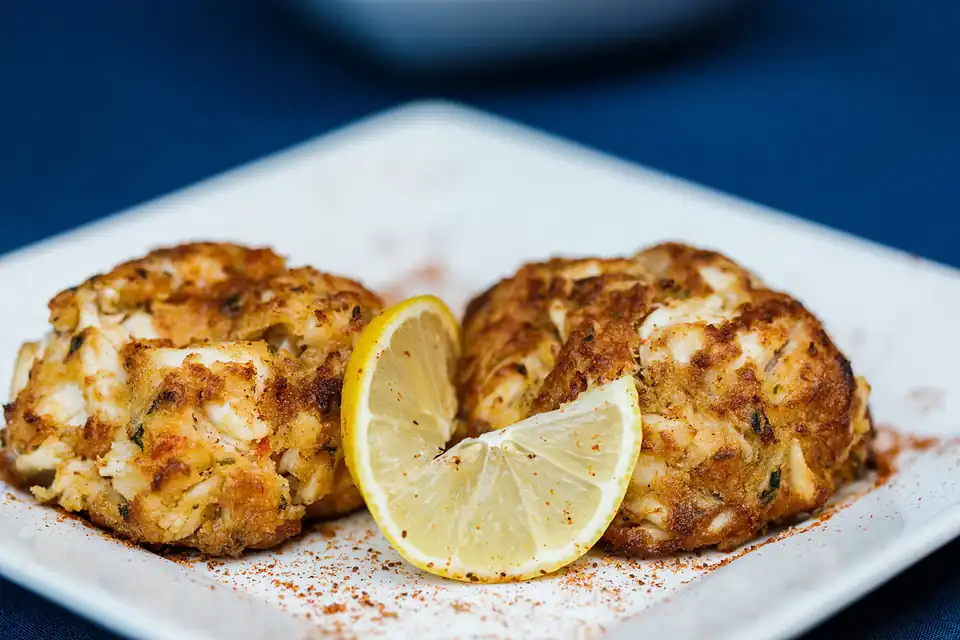 Two broiled jumbo lump crab cakes with a lemon wedge