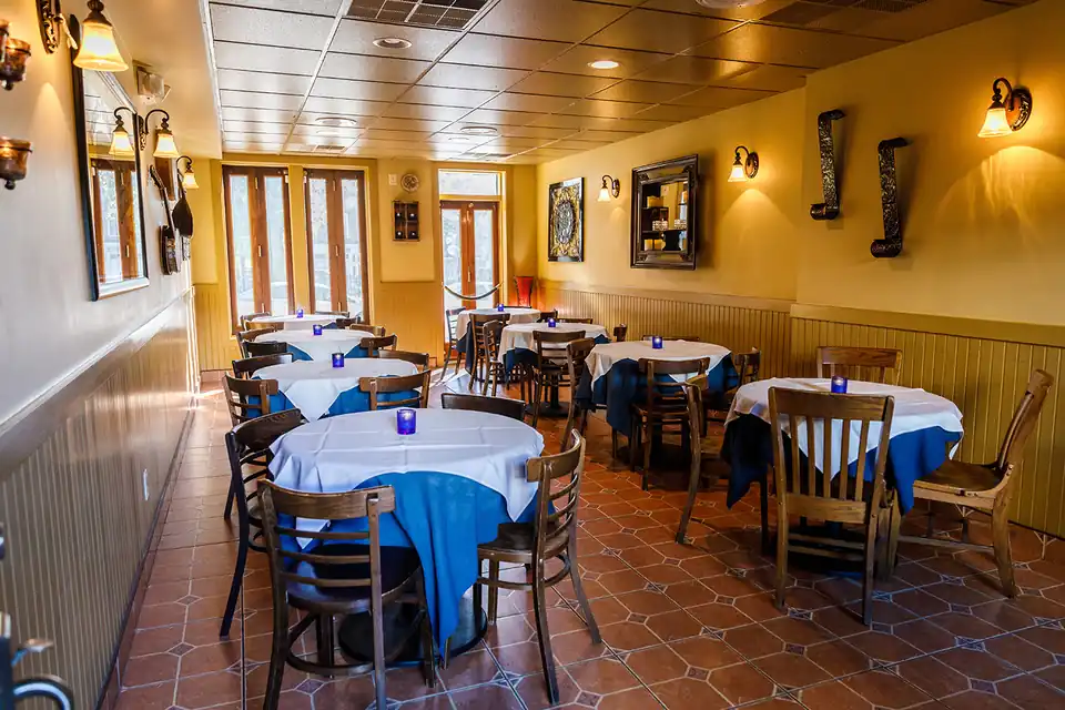 The private dining room laid with white linens and blue napkins